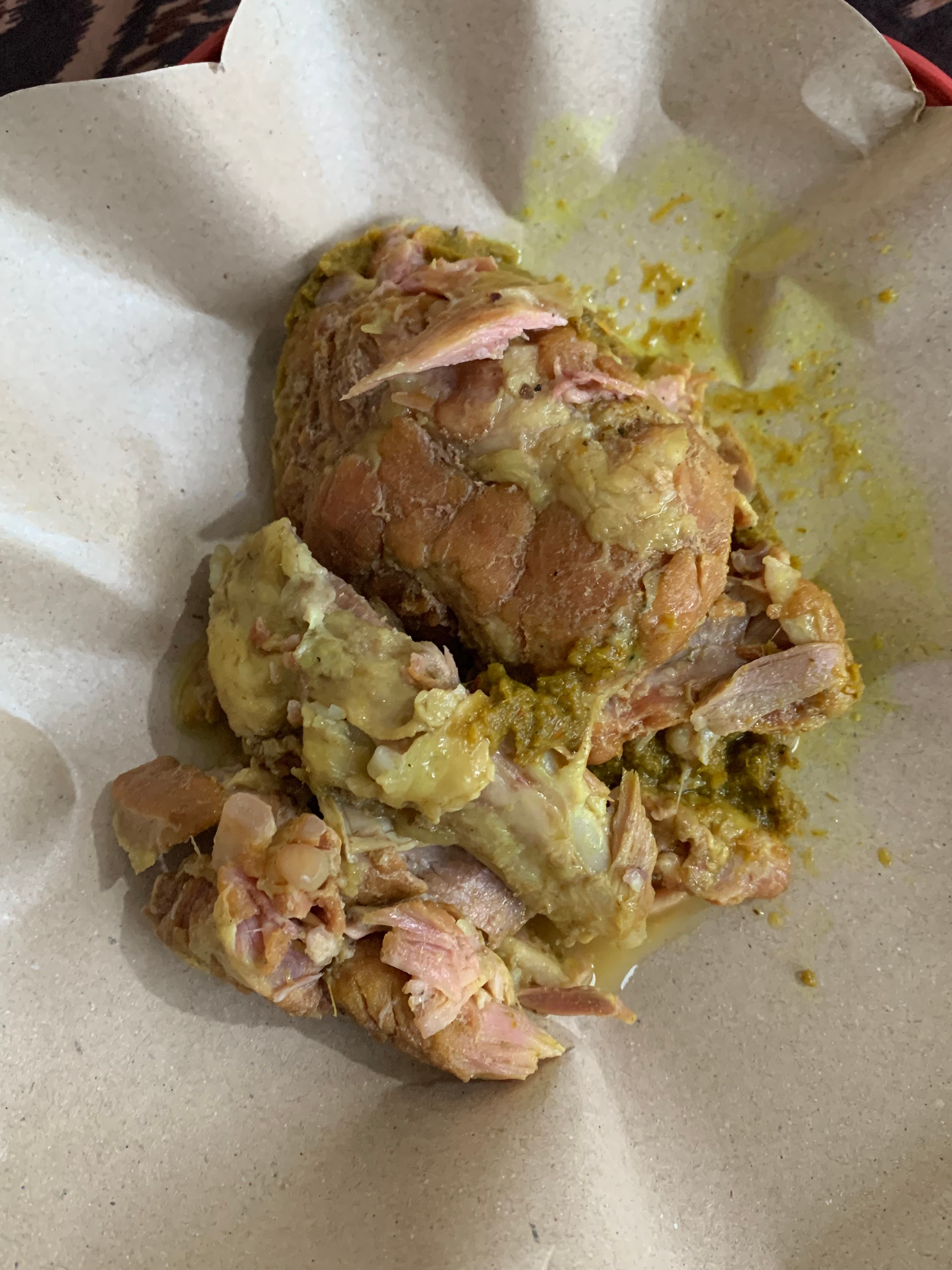 Potongan Be Genyol berbumbu kuning kehijauan yang empuk di atas kertas bungkus