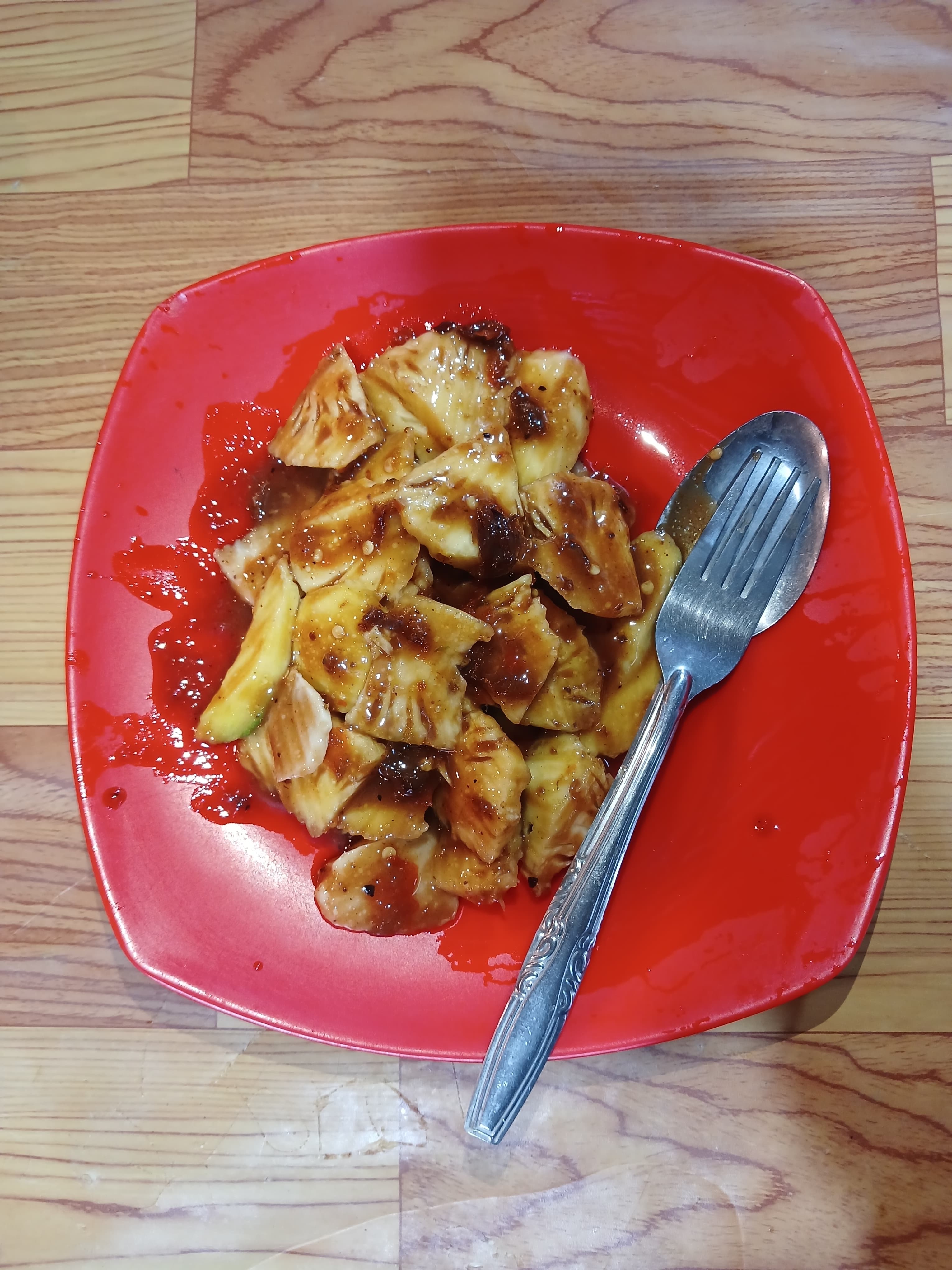Rujak Gula Bali berupa potongan buah disiram bumbu gula aren, cabai, dan terasi di atas piring merah