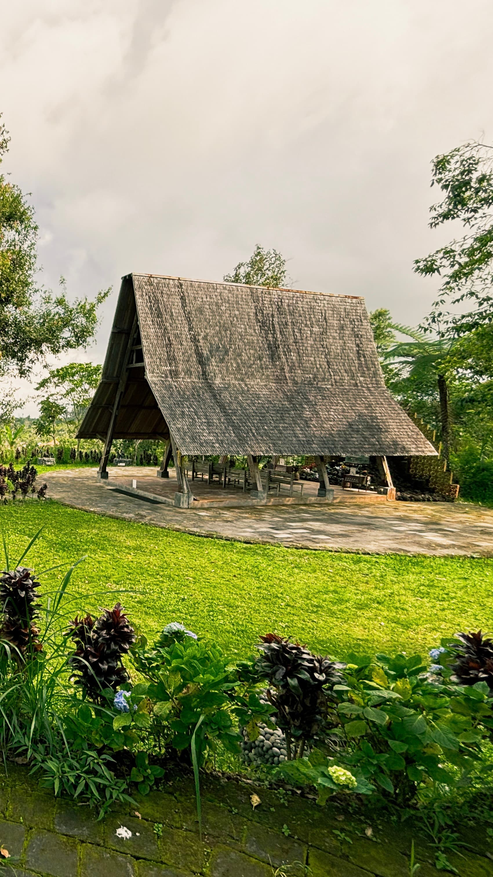 Paviliun kayu beratap sirap di taman hijau kompleks Goa Maria Ratu Surga, Pelaga